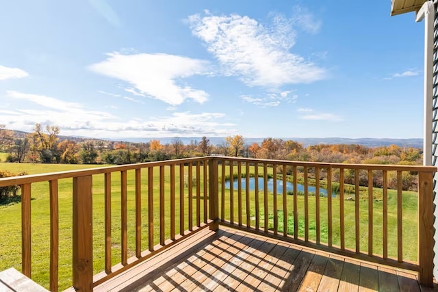 wooden deck featuring a lawn and a water view