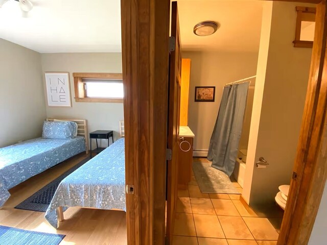 bedroom featuring a baseboard radiator and light tile patterned flooring