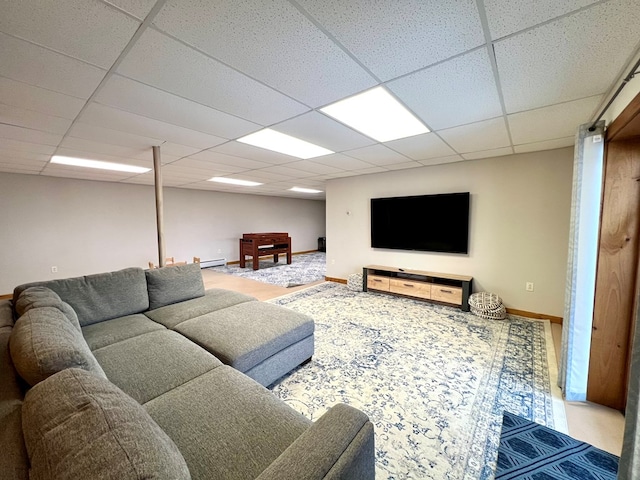 living room featuring a paneled ceiling and baseboard heating