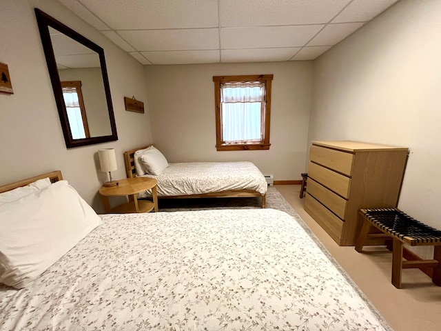 bedroom with a drop ceiling and baseboard heating