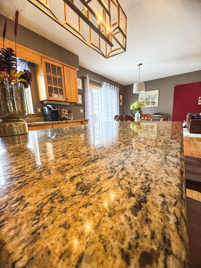 kitchen with hanging light fixtures and stone counters