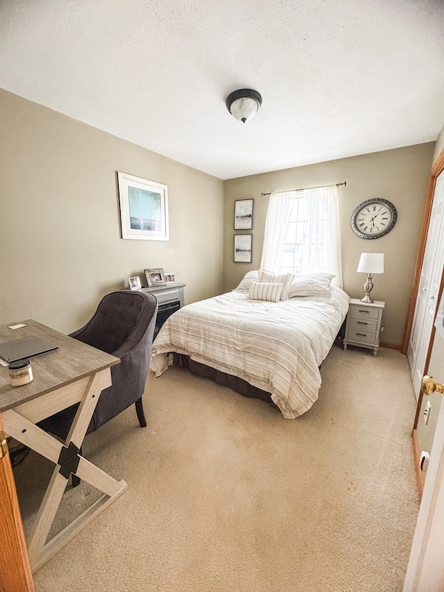 bedroom featuring light colored carpet and a textured ceiling