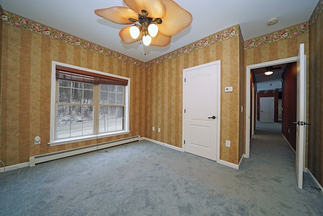 carpeted spare room with a baseboard radiator and ceiling fan