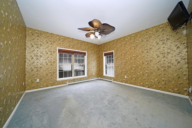 carpeted spare room with ceiling fan and a baseboard heating unit