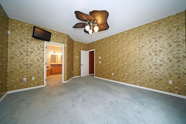 unfurnished bedroom with ceiling fan, connected bathroom, and carpet