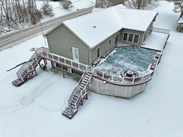 snow covered house featuring a wooden deck