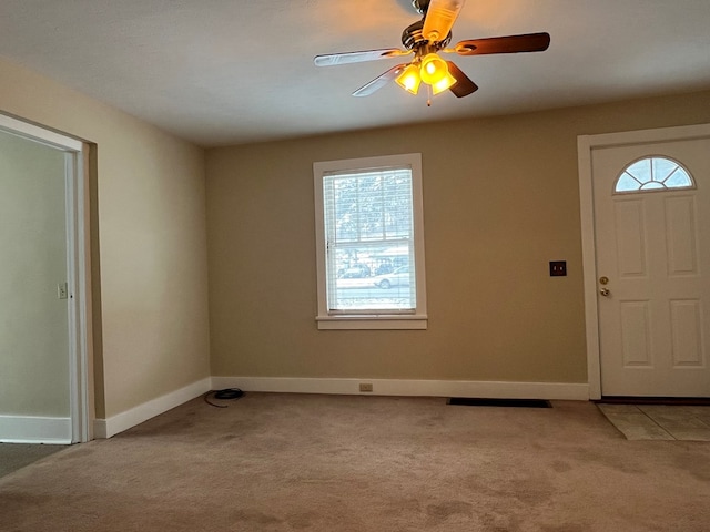 foyer featuring ceiling fan and light carpet