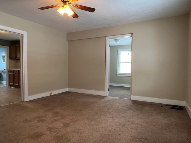 spare room with ceiling fan and dark carpet