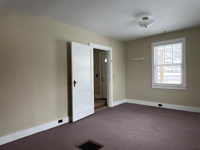 empty room featuring dark colored carpet