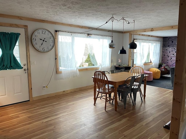 dining space with hardwood / wood-style flooring and a textured ceiling