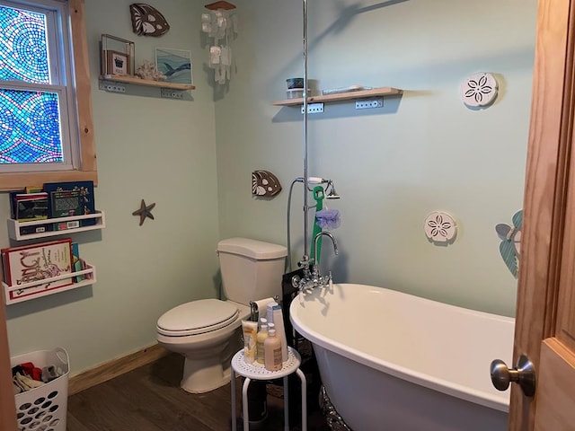 bathroom with a bathtub, toilet, and hardwood / wood-style flooring