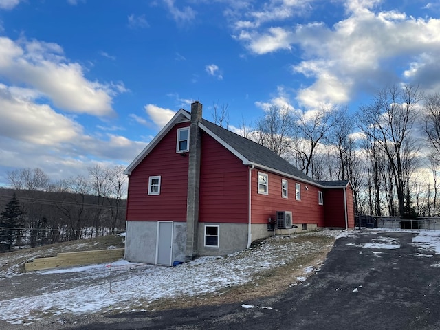 view of snow covered exterior featuring central AC