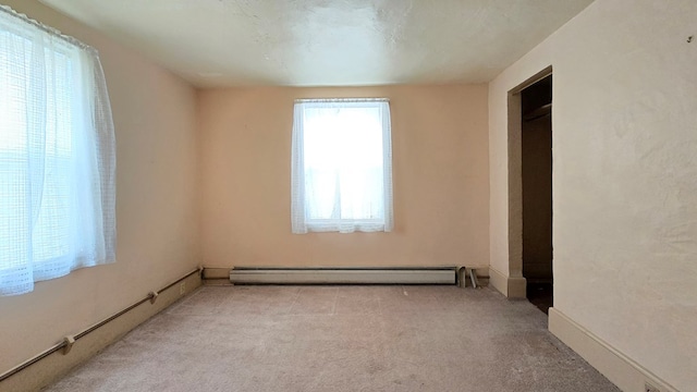 unfurnished bedroom featuring light carpet and a baseboard radiator