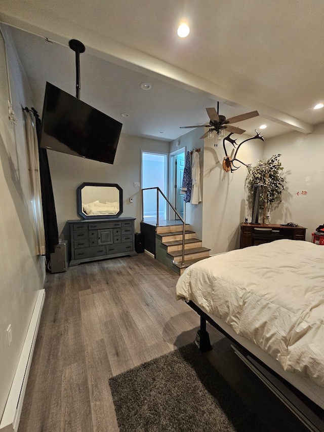 bedroom featuring beam ceiling, a baseboard radiator, wood-type flooring, and ceiling fan