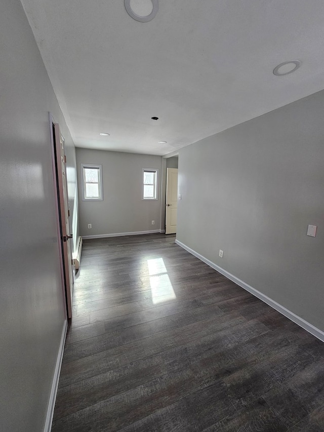 unfurnished room with dark wood-type flooring