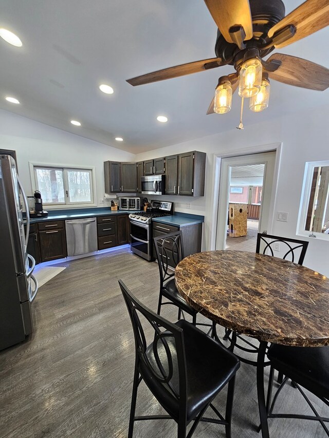 dining area with vaulted ceiling, plenty of natural light, and light hardwood / wood-style floors