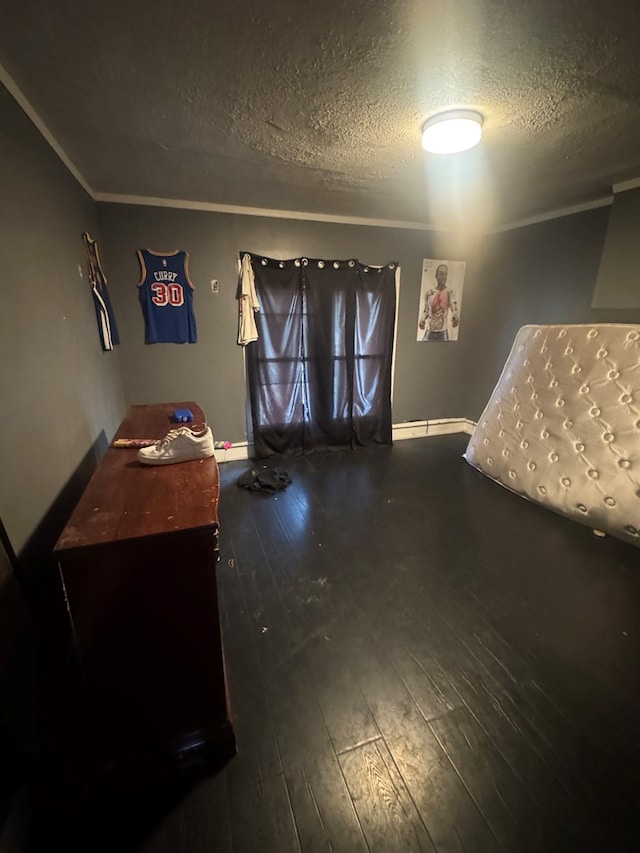 bedroom with a textured ceiling and dark hardwood / wood-style flooring