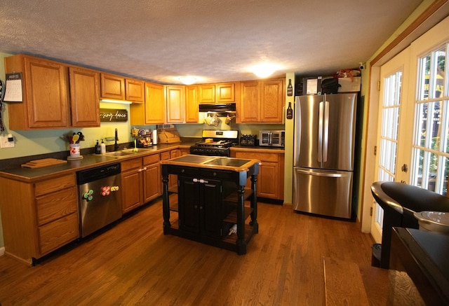 kitchen with sink, dark wood-type flooring, a textured ceiling, and appliances with stainless steel finishes