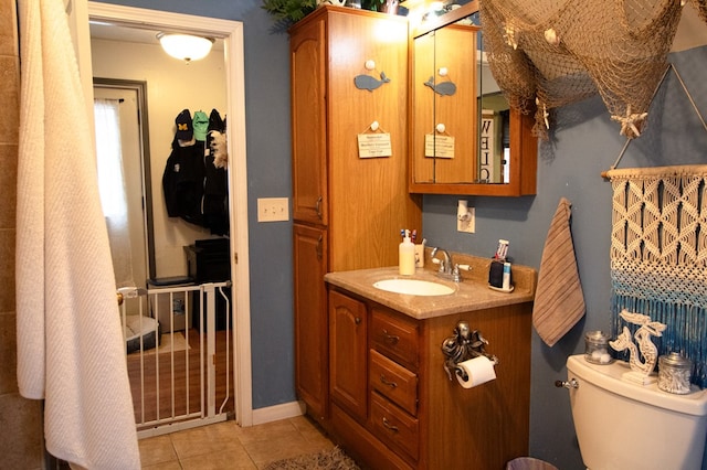 bathroom with vanity, toilet, and tile patterned floors