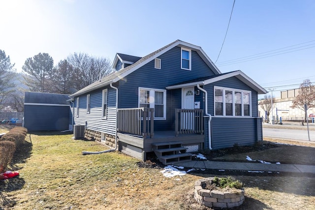 view of front of property with central AC and a front yard