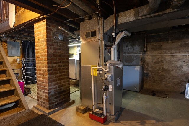 basement featuring heating unit, washer / dryer, and electric panel