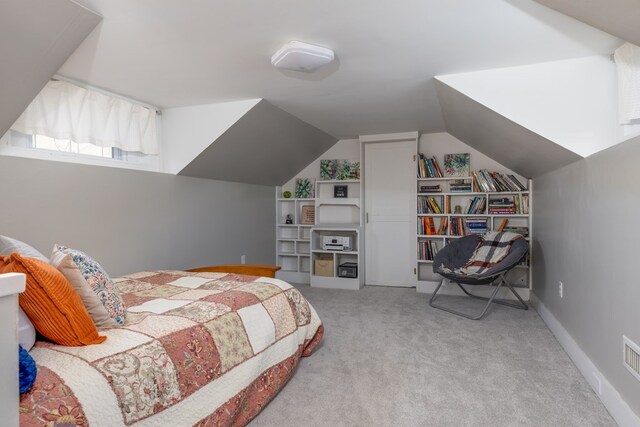 bedroom with light colored carpet and vaulted ceiling