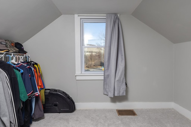 spacious closet with lofted ceiling and light colored carpet