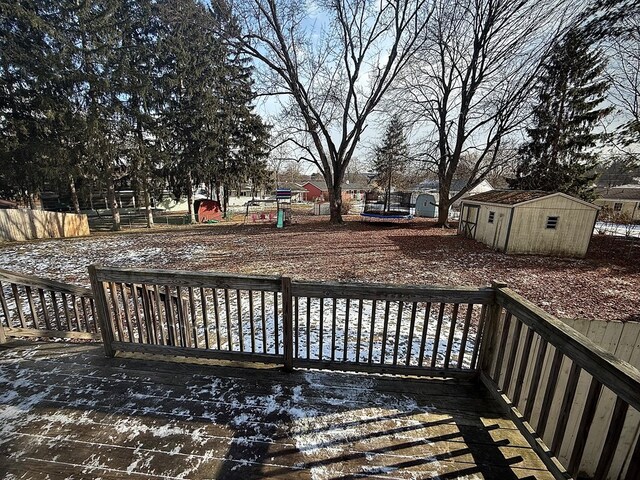 snow covered deck featuring a storage unit