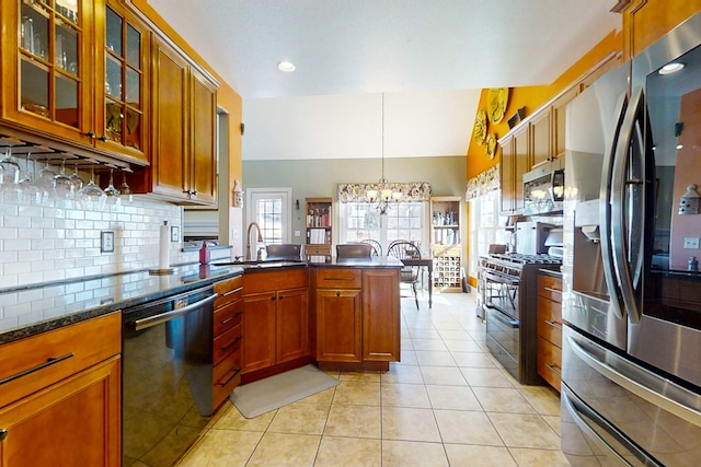 kitchen featuring lofted ceiling, hanging light fixtures, stainless steel appliances, light tile patterned flooring, and kitchen peninsula