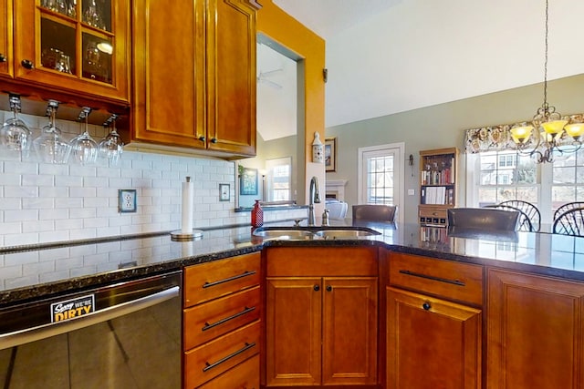 kitchen with sink, hanging light fixtures, dishwasher, dark stone counters, and decorative backsplash