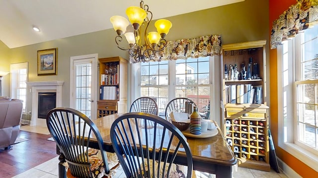 dining area featuring an inviting chandelier, lofted ceiling, and light tile patterned flooring