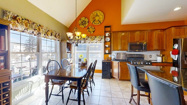 kitchen with pendant lighting, light tile patterned floors, an inviting chandelier, stainless steel appliances, and dark stone counters