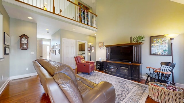 living room featuring dark wood-type flooring and a high ceiling