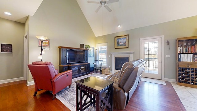 living room with ceiling fan, hardwood / wood-style floors, and high vaulted ceiling