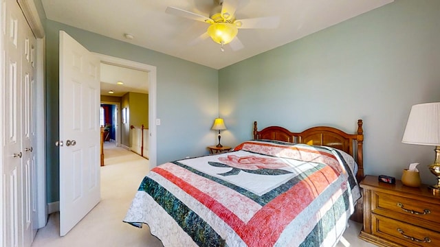 bedroom with ceiling fan, light colored carpet, and a closet