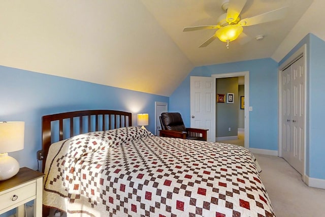 carpeted bedroom with vaulted ceiling, a closet, and ceiling fan