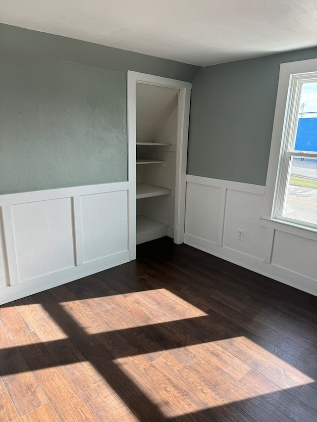 unfurnished bedroom featuring dark hardwood / wood-style flooring and multiple windows