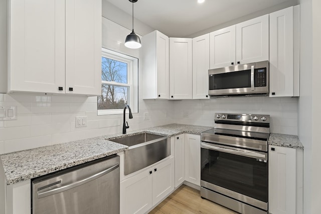 kitchen featuring backsplash, stainless steel appliances, sink, and white cabinets