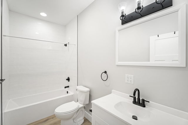 full bathroom featuring vanity, tiled shower / bath, wood-type flooring, and toilet