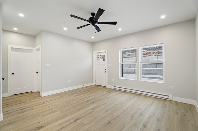 unfurnished room with ceiling fan, a baseboard heating unit, and light hardwood / wood-style floors