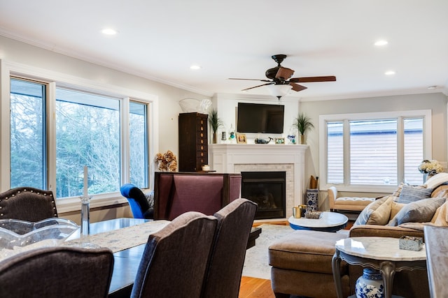 living room with wood-type flooring, ornamental molding, and a healthy amount of sunlight