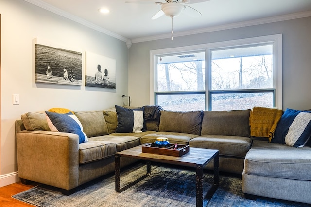 living room featuring wood-type flooring, ornamental molding, and a healthy amount of sunlight