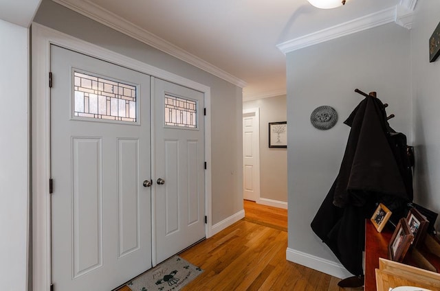 foyer entrance with ornamental molding and light wood-type flooring