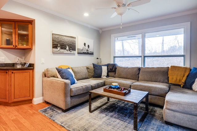 living room featuring plenty of natural light, ornamental molding, and light wood-type flooring