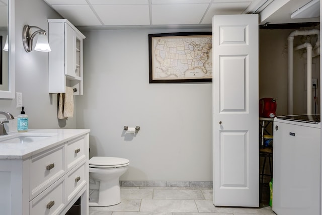 bathroom featuring vanity, a paneled ceiling, tile patterned floors, and toilet