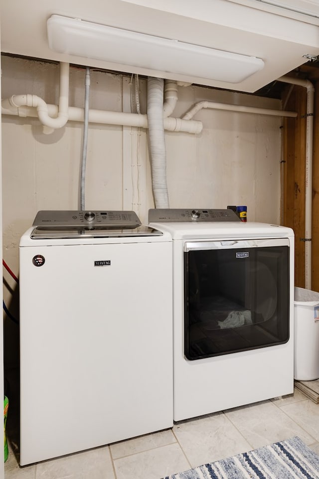 clothes washing area with light tile patterned floors and washing machine and dryer