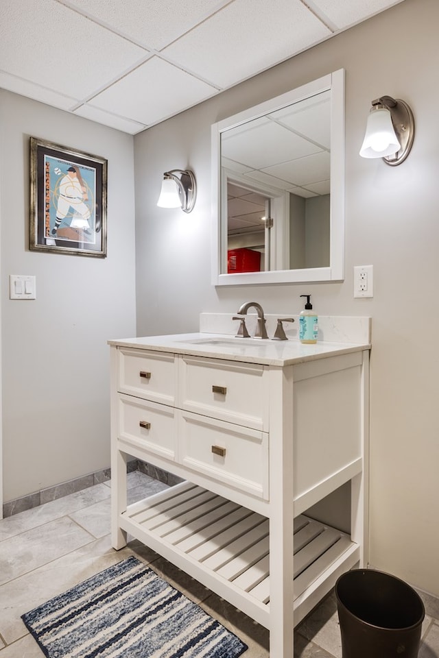 bathroom with a paneled ceiling and vanity