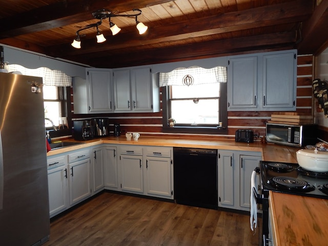 kitchen featuring sink, wooden counters, appliances with stainless steel finishes, beam ceiling, and white cabinets