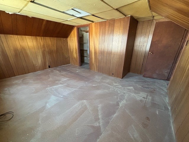 additional living space with lofted ceiling and wooden walls