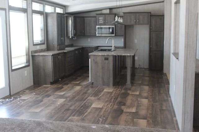 kitchen featuring hanging light fixtures, sink, a center island with sink, and a wealth of natural light